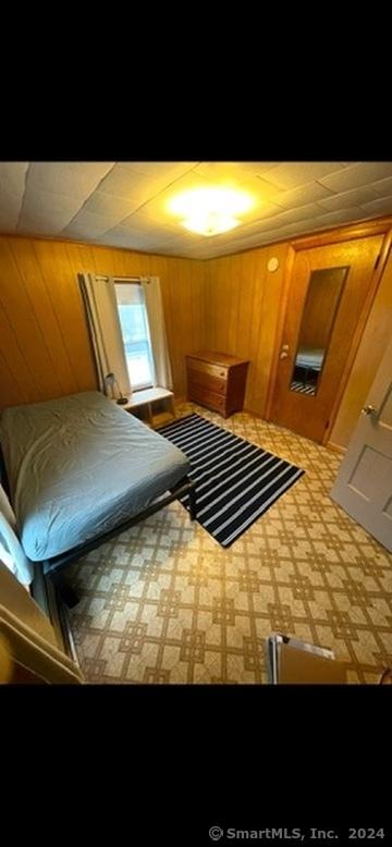 bedroom featuring wood walls