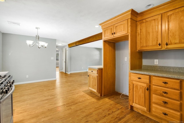 kitchen featuring pendant lighting, a notable chandelier, stainless steel range with gas cooktop, and light hardwood / wood-style flooring