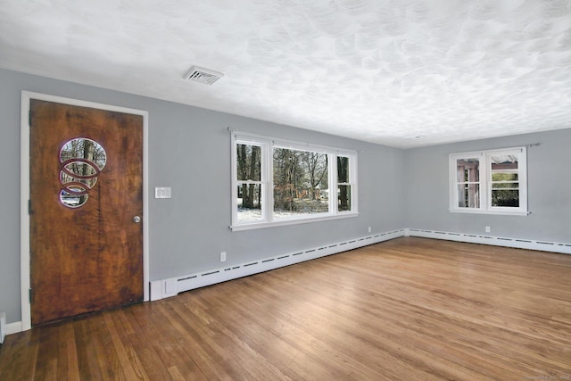 entrance foyer featuring baseboard heating, plenty of natural light, and a textured ceiling