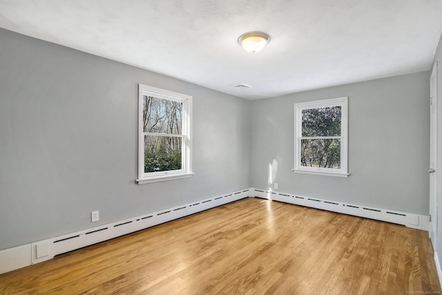 spare room with a baseboard radiator and light wood-type flooring