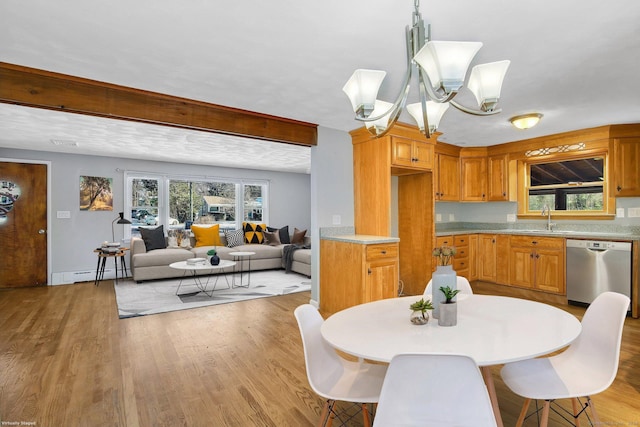 dining area with a baseboard heating unit, sink, beamed ceiling, a chandelier, and light hardwood / wood-style floors