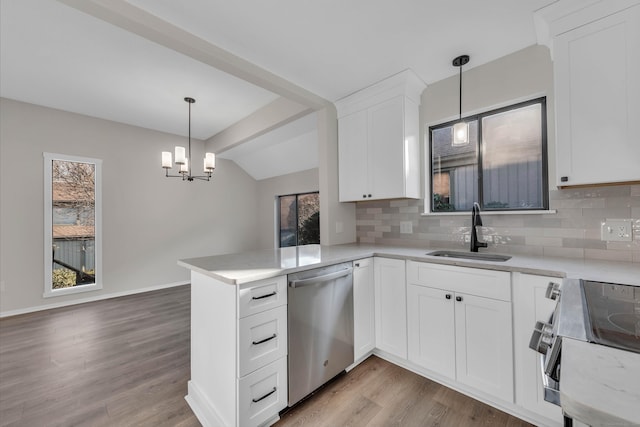 kitchen featuring white cabinetry, sink, hanging light fixtures, stainless steel dishwasher, and kitchen peninsula