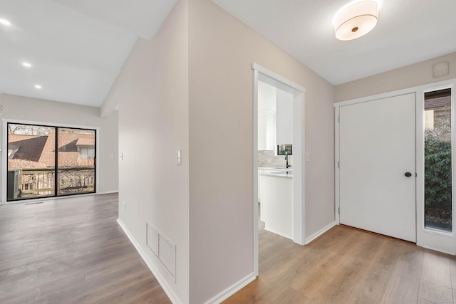 hallway featuring visible vents, recessed lighting, light wood-style floors, and baseboards