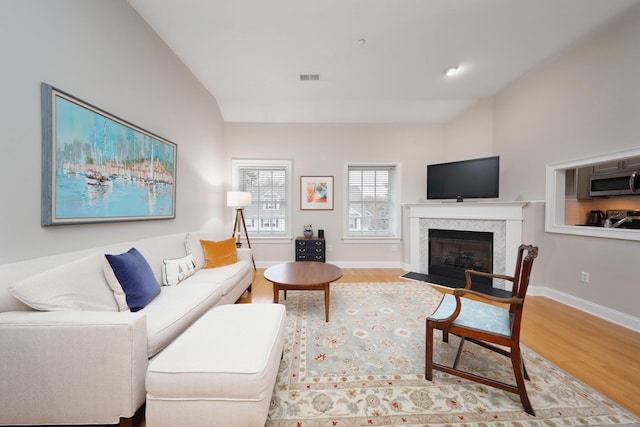 living room featuring wood-type flooring and vaulted ceiling