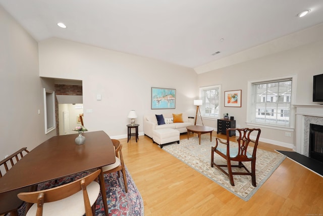 living room featuring light wood-type flooring and vaulted ceiling