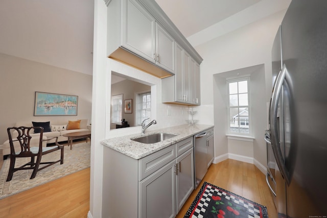 kitchen featuring gray cabinets, light hardwood / wood-style floors, sink, and stainless steel appliances