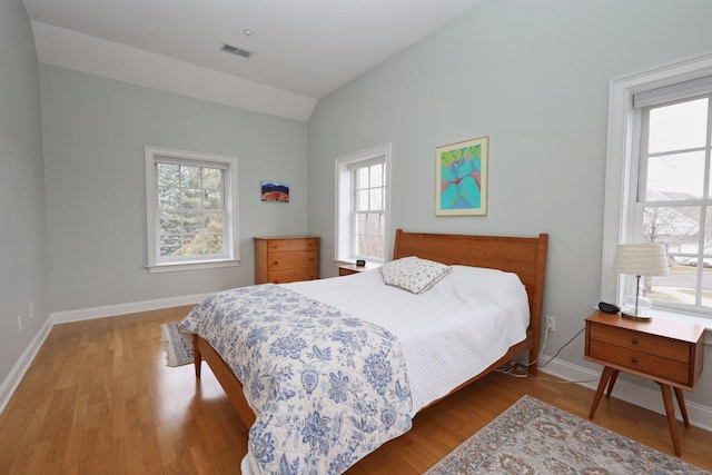 bedroom featuring light hardwood / wood-style flooring and lofted ceiling