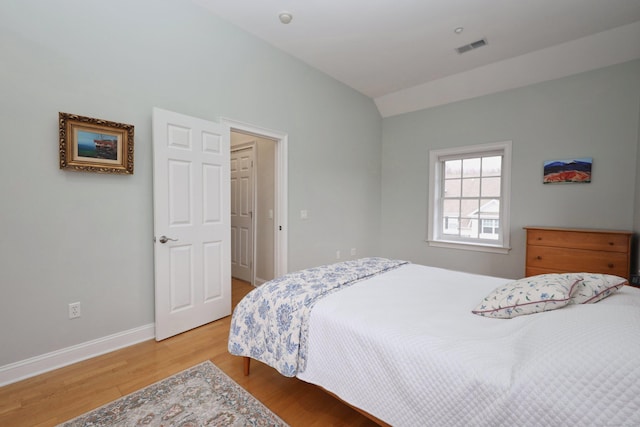 bedroom with hardwood / wood-style flooring and vaulted ceiling