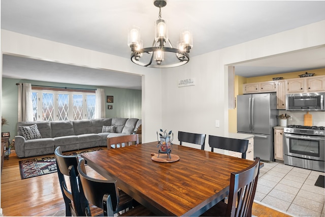 dining room with light hardwood / wood-style flooring and an inviting chandelier