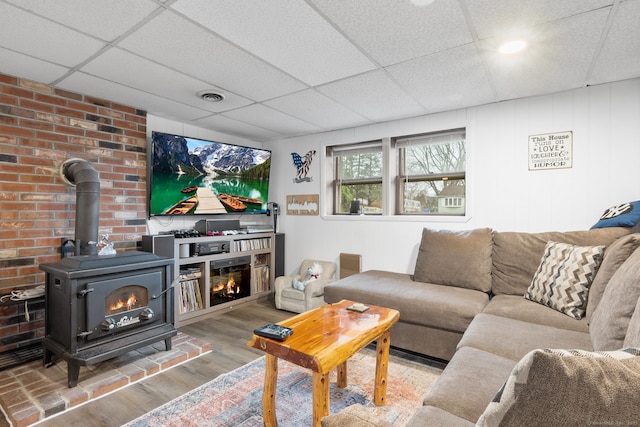 living room featuring a drop ceiling and wood-type flooring