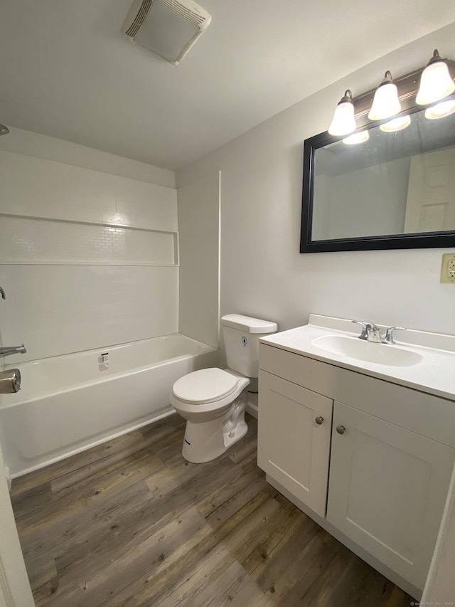 full bathroom featuring washtub / shower combination, hardwood / wood-style floors, vanity, and toilet