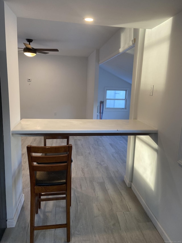 kitchen featuring ceiling fan, wood-type flooring, and lofted ceiling