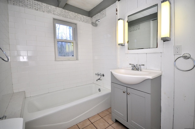 bathroom featuring tile patterned flooring, vanity, and tiled shower / bath combo