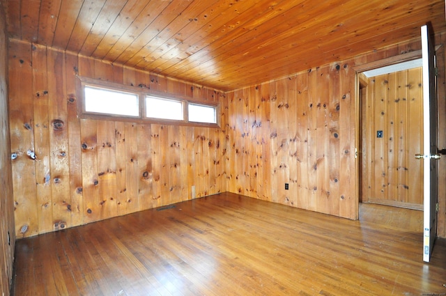 spare room with wooden walls and hardwood / wood-style floors