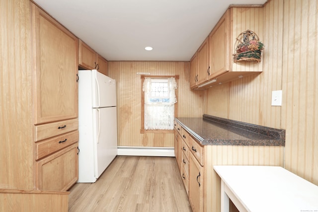 kitchen with light brown cabinetry, white refrigerator, and baseboard heating