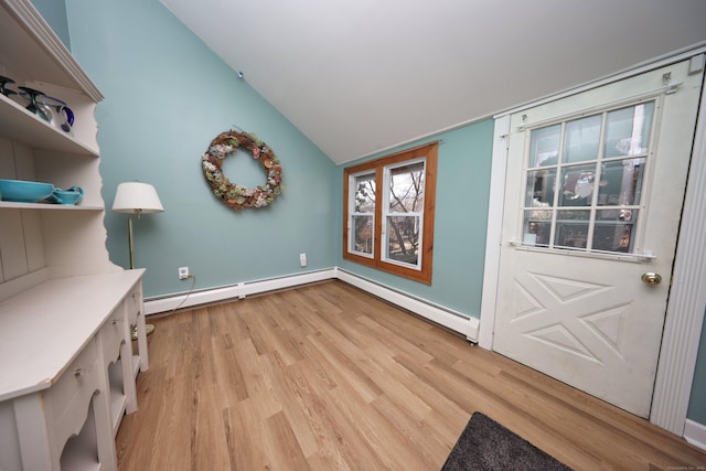 interior space featuring light wood-type flooring, a baseboard radiator, and vaulted ceiling