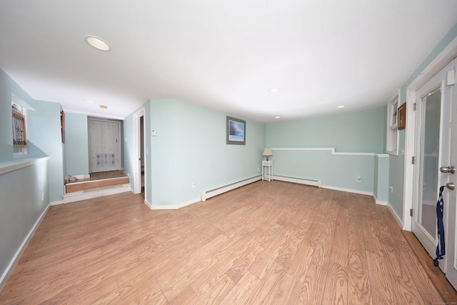 interior space with light wood-type flooring and baseboard heating