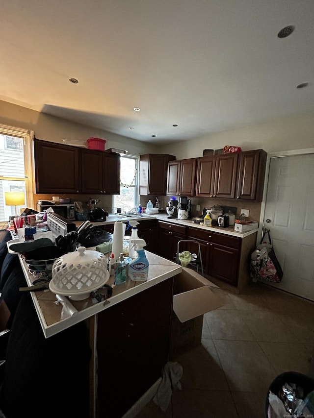 kitchen featuring light tile patterned floors and dark brown cabinets