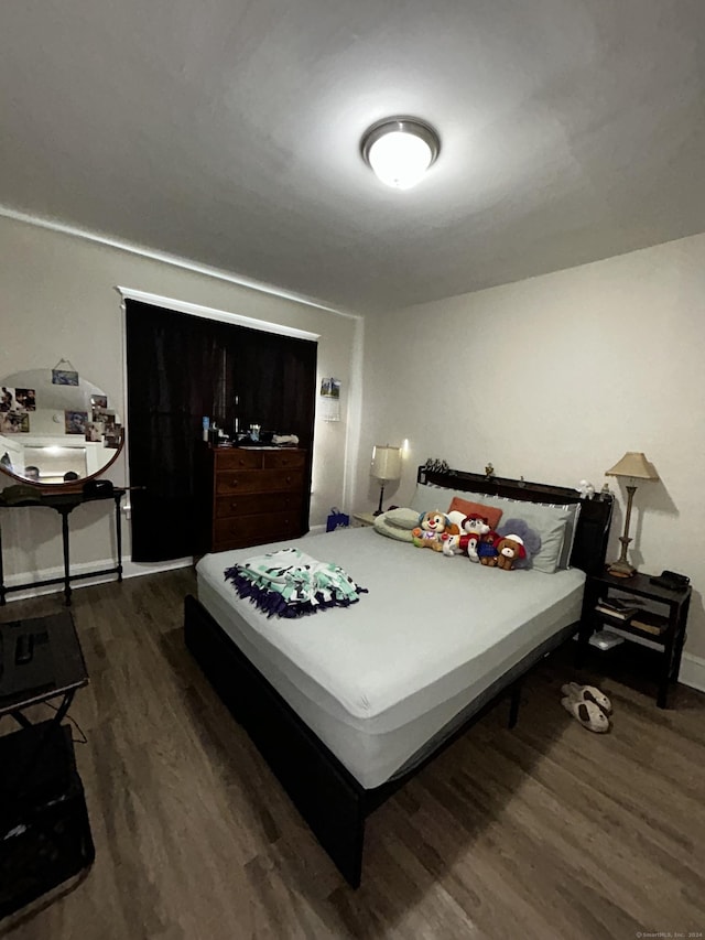 bedroom with dark hardwood / wood-style flooring