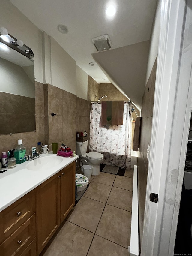 full bathroom with tile patterned flooring, a bidet, toilet, vanity, and tile walls