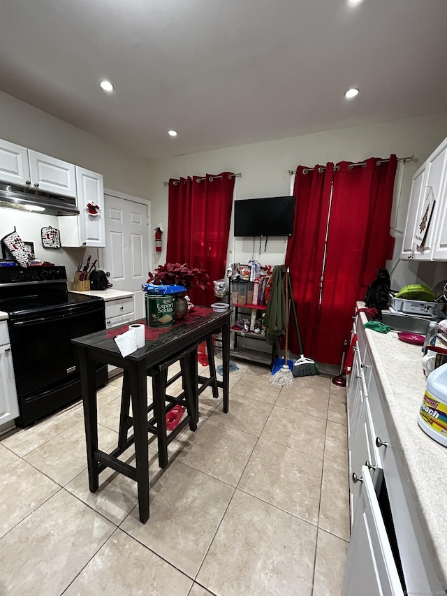 kitchen with white cabinetry, light tile patterned floors, and black / electric stove