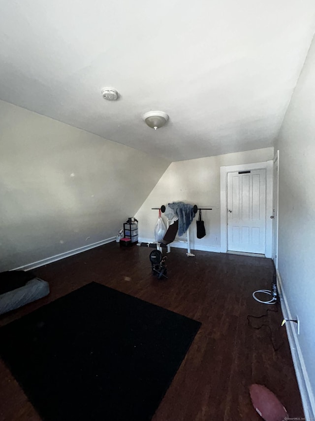 exercise area with dark hardwood / wood-style flooring and lofted ceiling