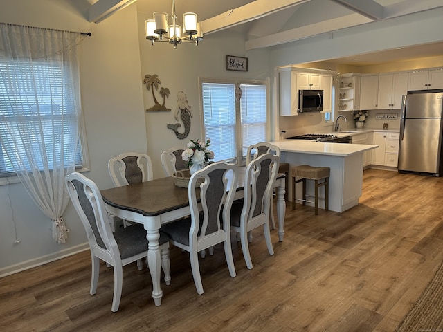 dining area featuring beam ceiling, sink, and plenty of natural light