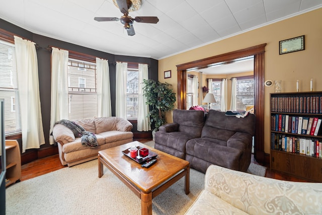 living room featuring hardwood / wood-style flooring, ceiling fan, and crown molding