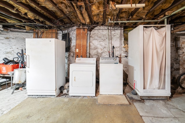 basement with washer and dryer and white refrigerator