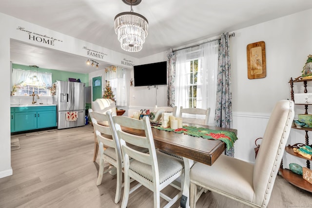 dining space featuring a notable chandelier, light hardwood / wood-style floors, and sink