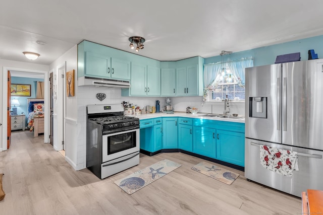 kitchen with decorative backsplash, sink, pendant lighting, stainless steel fridge with ice dispenser, and range with gas stovetop