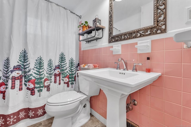 bathroom featuring walk in shower, tile patterned flooring, tile walls, and toilet