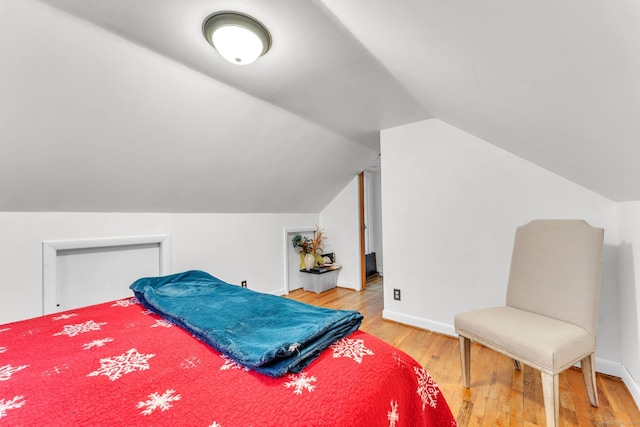 bedroom with lofted ceiling and hardwood / wood-style flooring