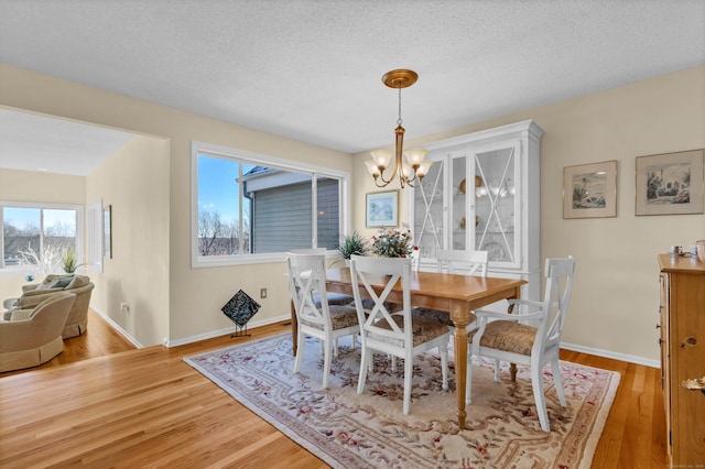 dining space featuring hardwood / wood-style floors, a chandelier, and a textured ceiling