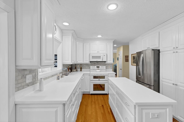 kitchen with white cabinetry, white appliances, and a center island