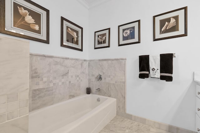 bathroom with ornamental molding, vanity, and a bath