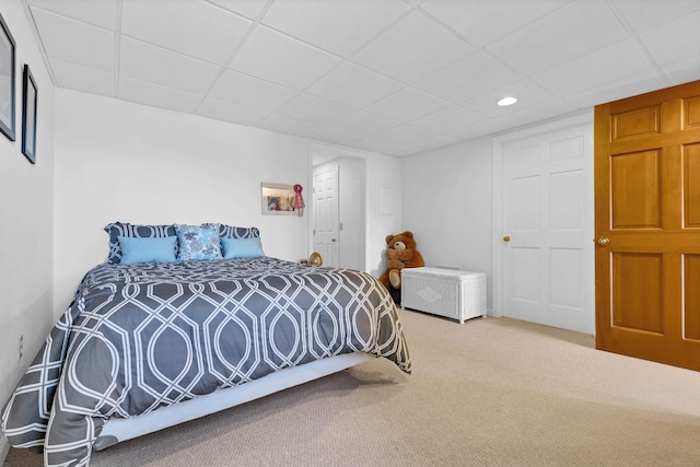 carpeted bedroom with a drop ceiling