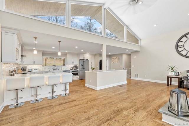 kitchen featuring stainless steel fridge, tasteful backsplash, decorative light fixtures, light hardwood / wood-style flooring, and white cabinetry