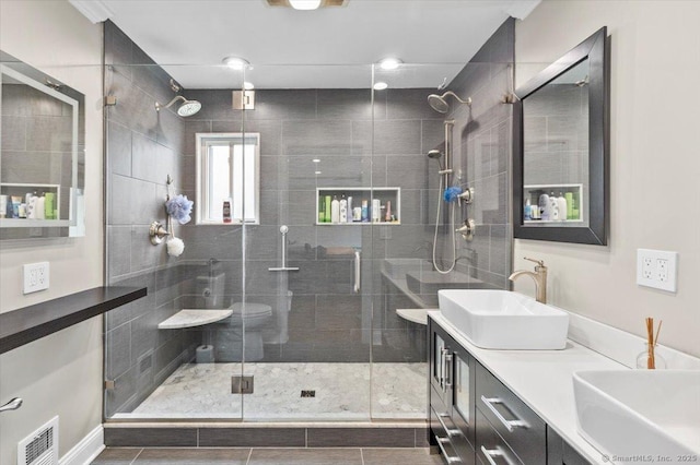 bathroom with tile patterned floors, a shower with door, and vanity