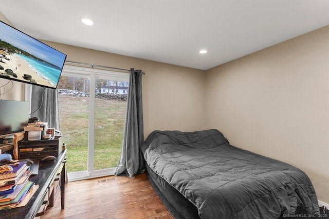 bedroom with access to exterior and hardwood / wood-style floors