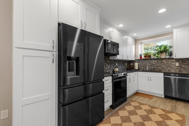 kitchen featuring black appliances, white cabinets, and sink