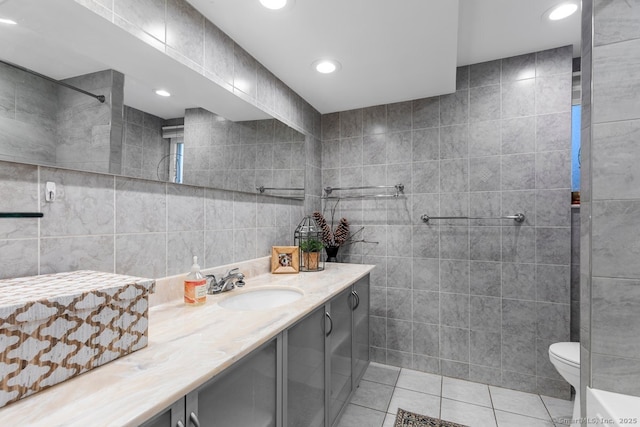 bathroom with tile patterned floors, vanity, toilet, and tile walls