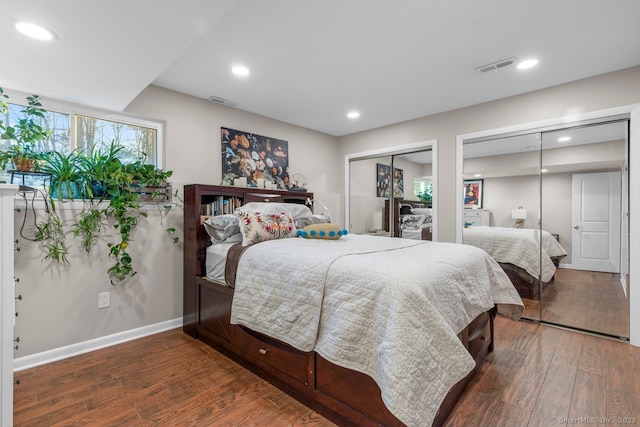 bedroom featuring multiple closets and dark wood-type flooring