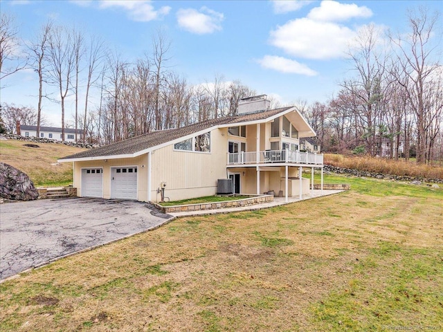 exterior space featuring a front yard, a garage, a deck, and central air condition unit