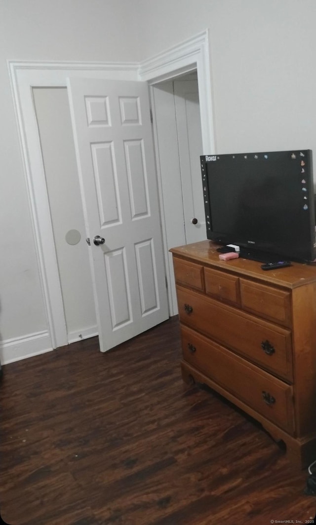 bedroom with dark wood-type flooring