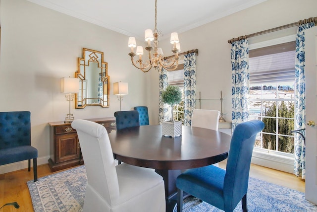 dining room with hardwood / wood-style floors, ornamental molding, and a chandelier