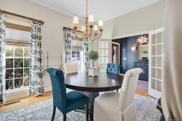 dining area featuring a chandelier, french doors, and hardwood / wood-style floors