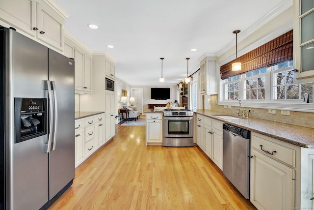 kitchen with sink, hanging light fixtures, tasteful backsplash, kitchen peninsula, and appliances with stainless steel finishes