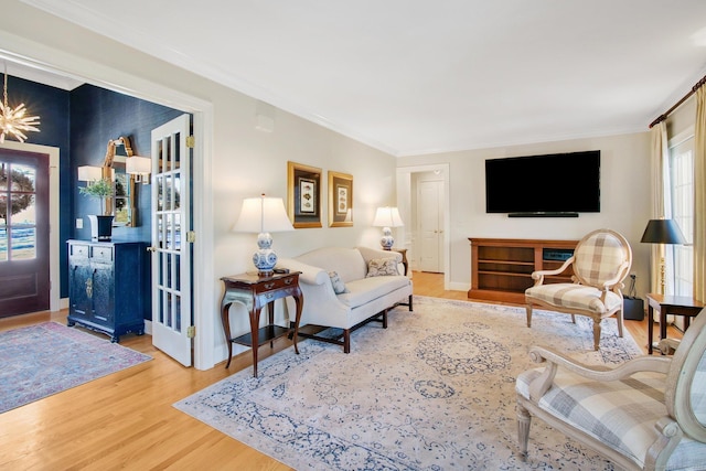 living room with ornamental molding and light hardwood / wood-style flooring