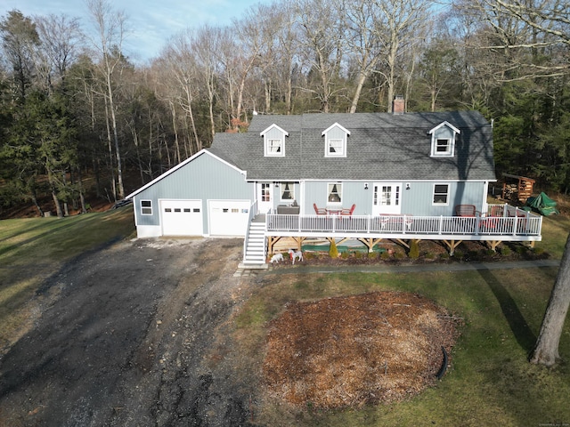 cape cod home with a garage and a front lawn